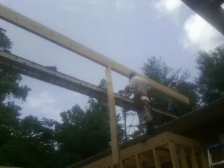 Carpenter setting a ridge beam over a new addition frame — Ice Dam Removal by Roofing Brothers in Phillipsburg