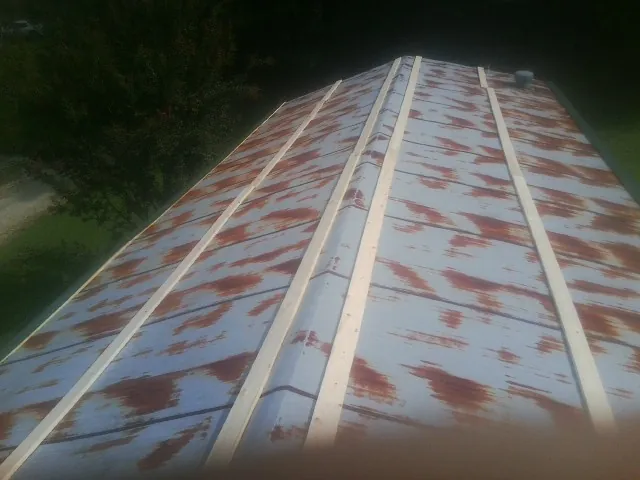 Rusted metal roof panels with new wood purlins before replacement — Storm Damage Roof Repair in Phillipsburg by Roofing Brothers