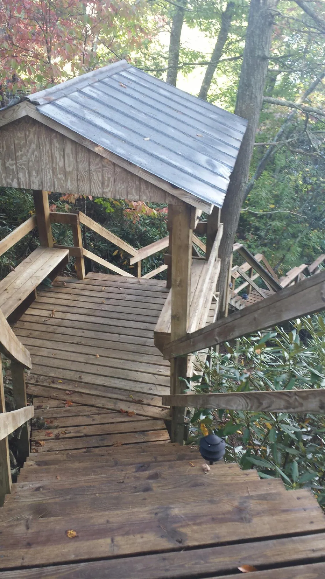 Metal roofed shelter over wooden steps on a wooded walkway — Skylight Repair & Installation work by our crew in Phillipsburg